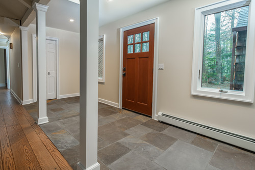Home entryway featuring a wooden front door, white trim, and light green walls.
