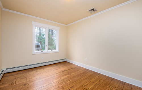 Empty room with light-colored walls, white baseboards, and a ceiling fan.