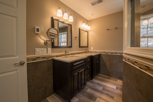 Modern master bathroom featuring a double vanity, large mirror, and glass shower enclosure.